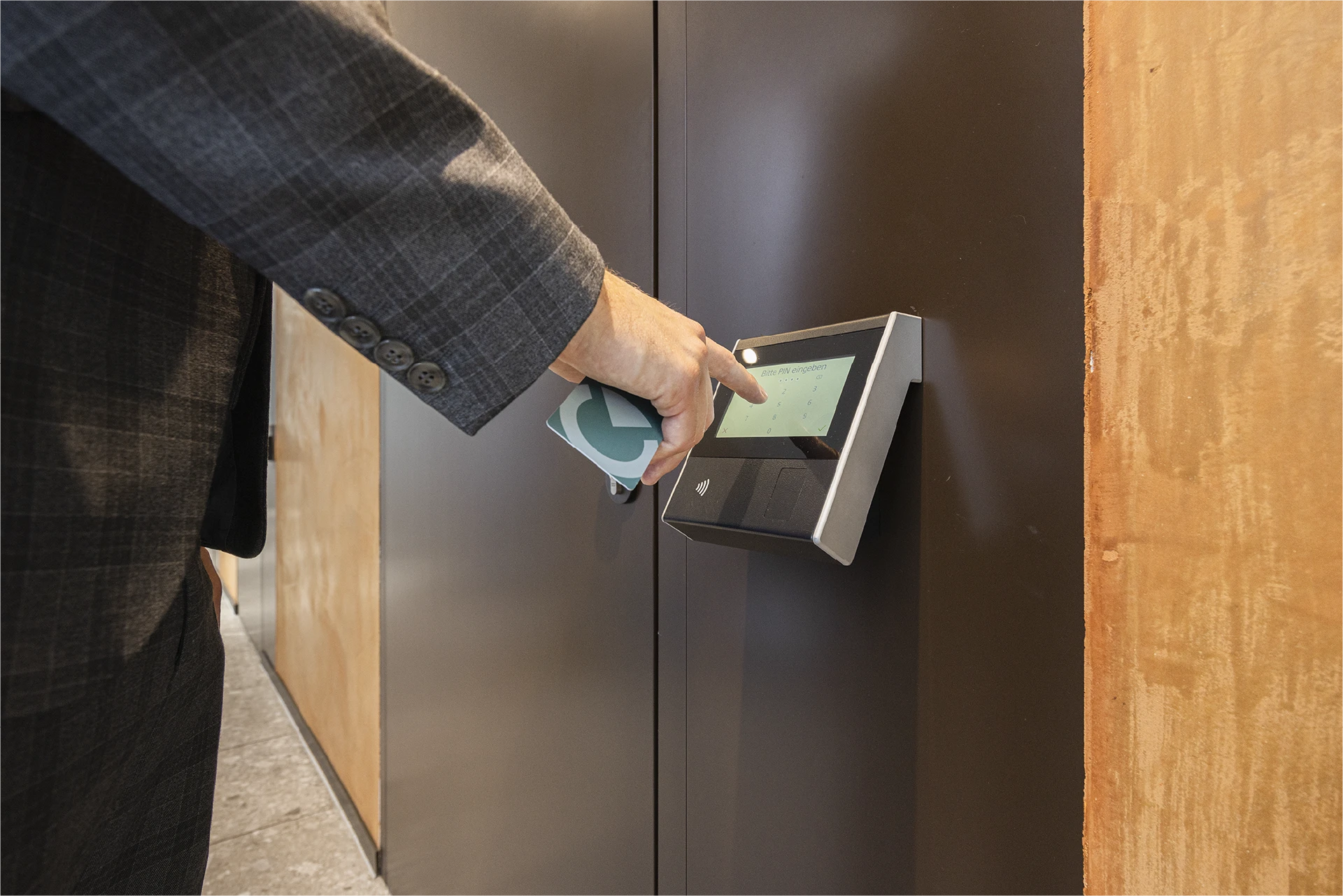 Hand hält eine Trisor-Kundenkarte an einem PIN-Code-Terminal in der Kabine