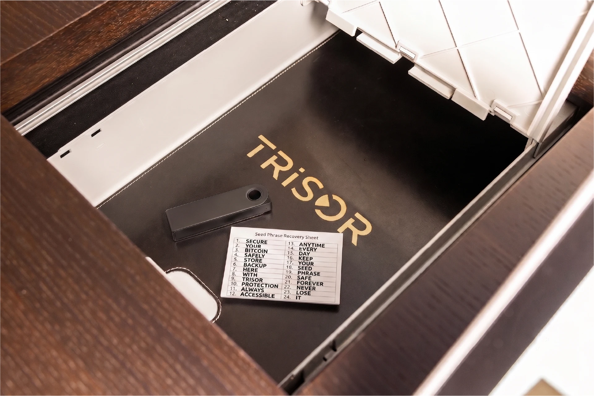 Hardware-Wallet und Seed-Phrase-Backup in einem geöffneten Trisor-Schließfach