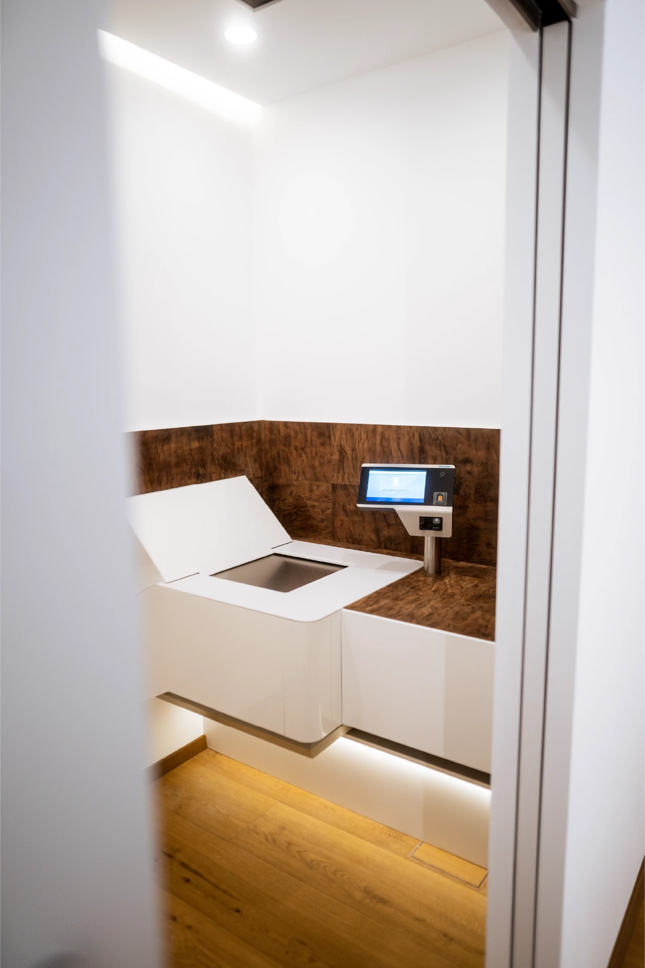 Blick in eine moderne Kundenkabine bei Trisor Berlin mit weißem Ausgabefach und Fingerabdrucksensor.