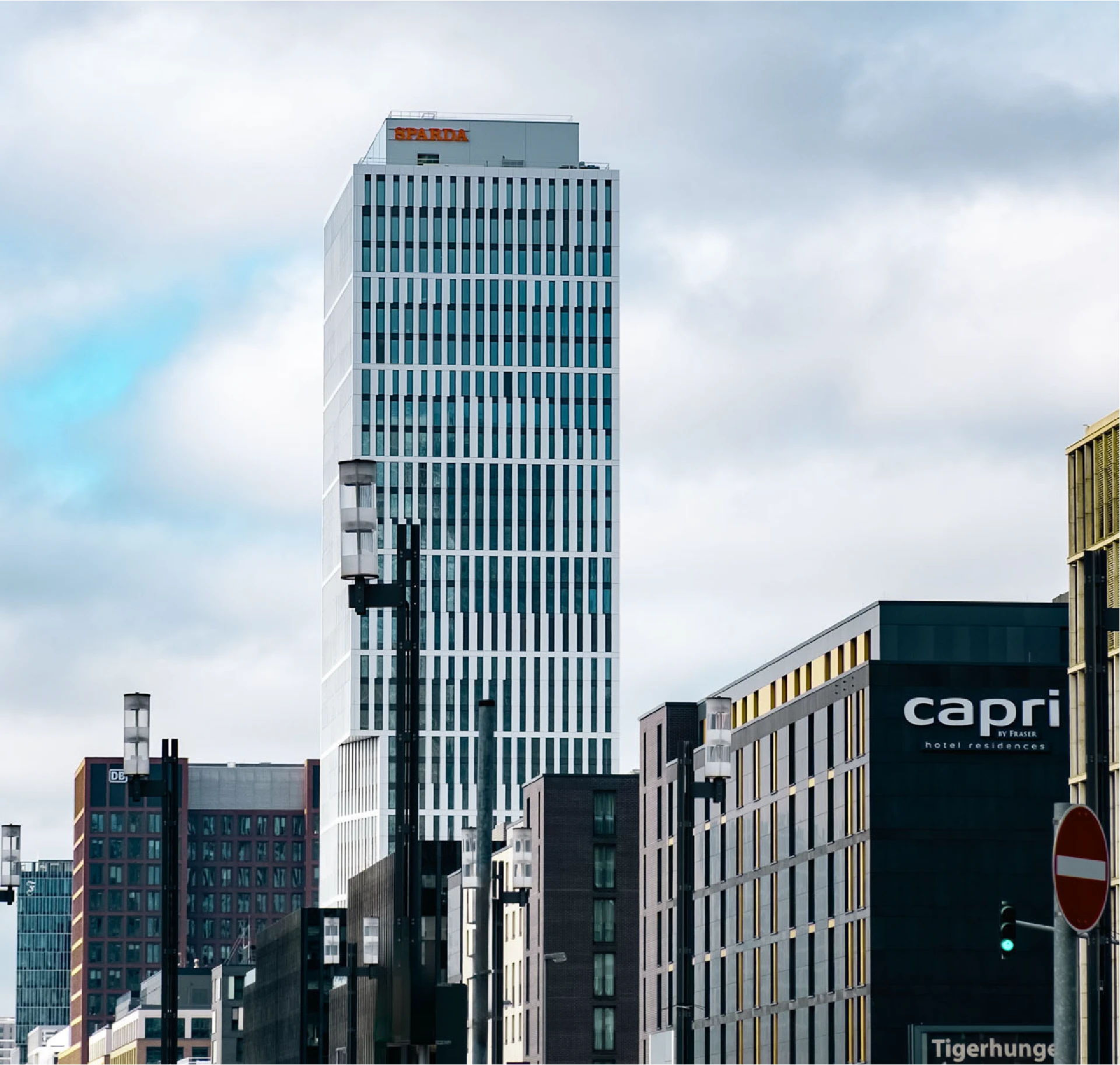 برج حديث مرتفع يحمل شعار Sparda Bank على سطحه وسط أفق المدينة