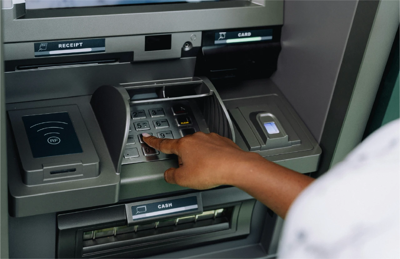 Dłoń wprowadzająca kod PIN w bankomacie