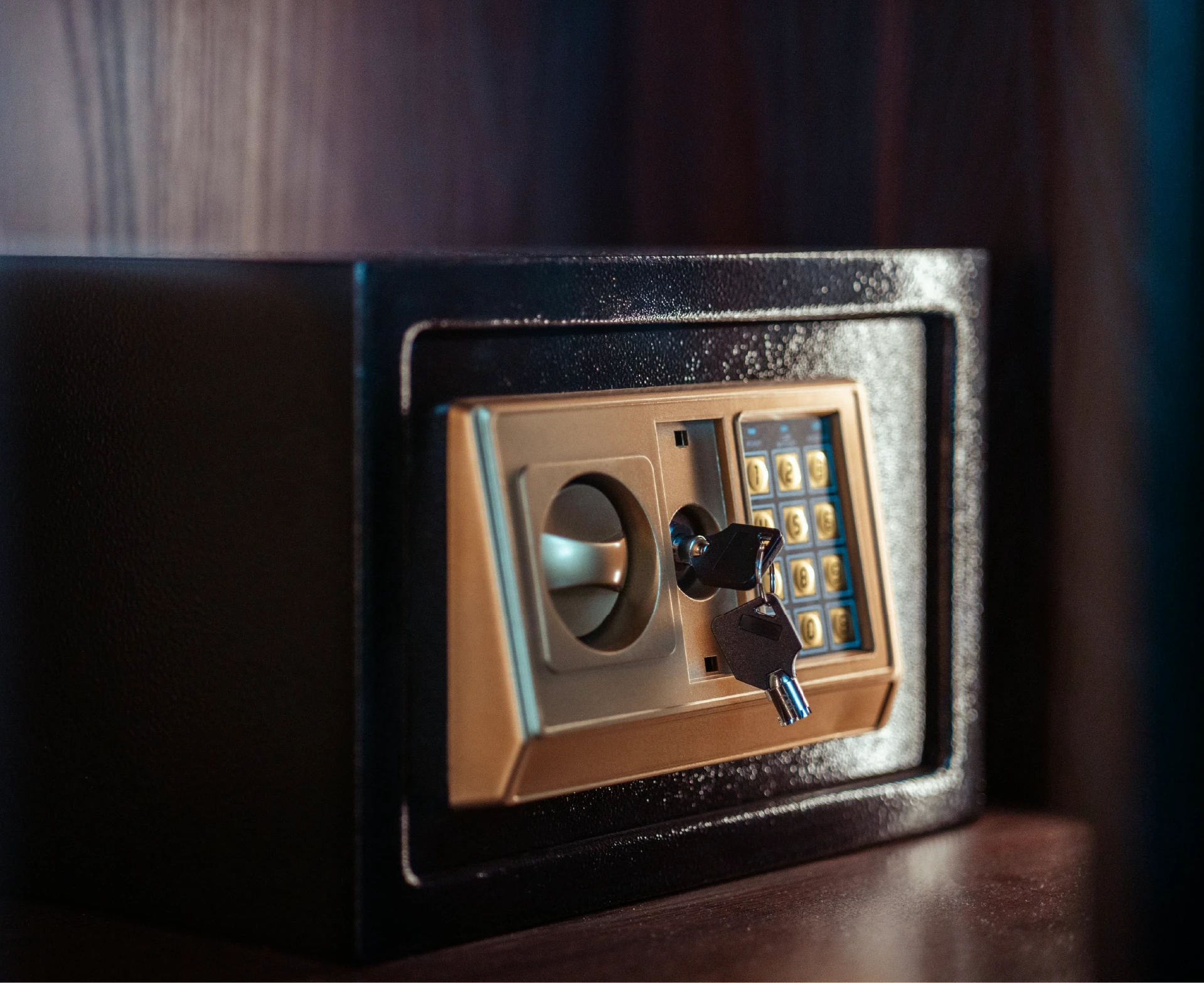 Small home safe with combination lock and key on a shelf